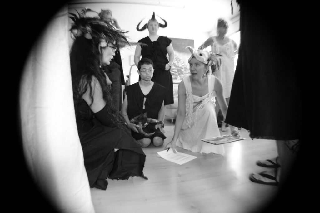 performers gather around the director to look at maps and diagrams